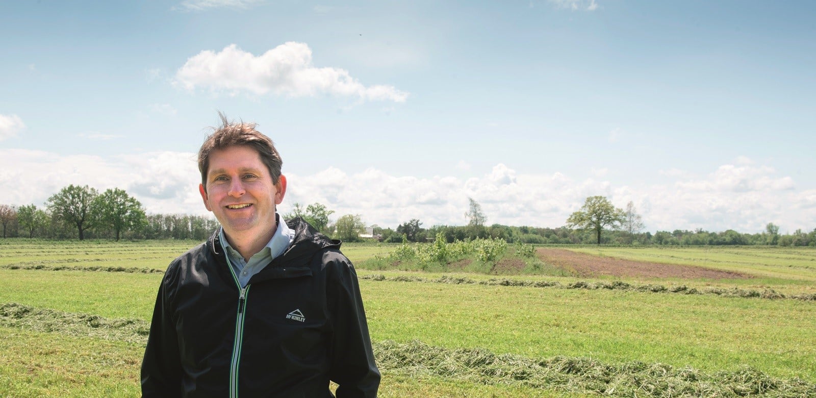 Dr. Christian Böhm steht auf einem Feld mit Agroforstsystem